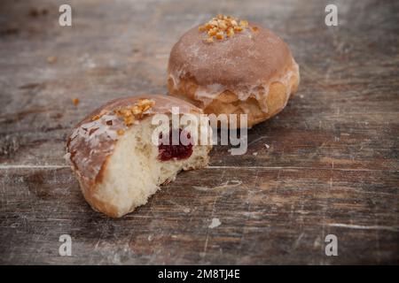 Gros jeudi. Photos de beignets avec garniture de cerise et glaçage. Beignets disposés sur un fond rustique. Banque D'Images