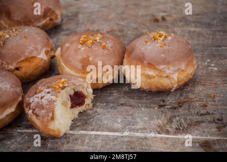 Gros jeudi. Photos de beignets avec garniture de cerise et glaçage. Beignets disposés sur un fond rustique. Banque D'Images