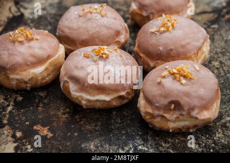 Gros jeudi. Photos de beignets avec garniture de cerise et glaçage. Beignets disposés sur un fond rustique. Banque D'Images