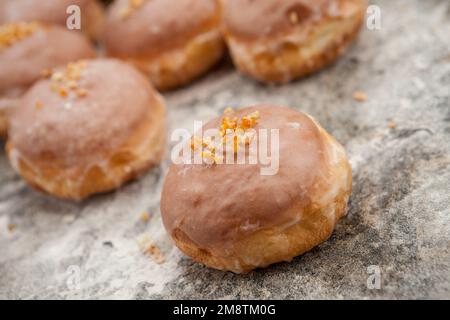 Gros jeudi. Photos de beignets avec garniture de cerise et glaçage. Beignets disposés sur un fond rustique. Banque D'Images