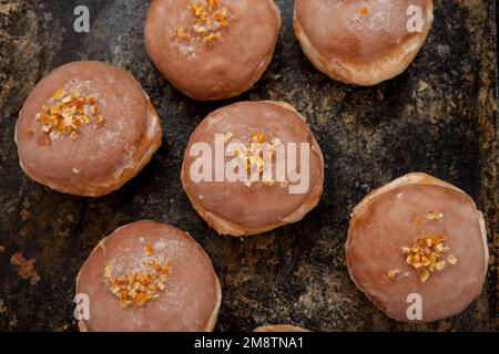 Gros jeudi. Photos de beignets avec garniture de cerise et glaçage. Beignets disposés sur un fond rustique. Banque D'Images