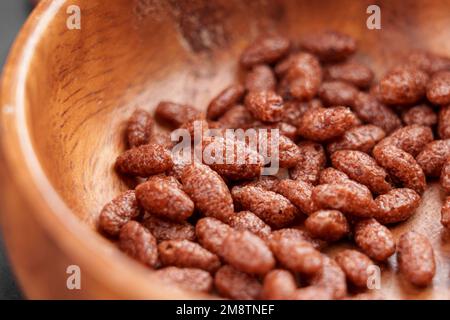 Petit déjeuner croustillant de céréales de riz au chocolat dans un bol en bois en gros plan Banque D'Images