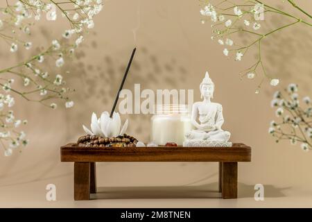 Soin de soi encore la vie avec Bouddha statue, bougie, bâton d'arôme sur le podium en bois avec des fleurs blanches. Procédure de rituel asiatique de spa. Concept de santé mentale Banque D'Images