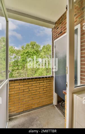 un balcon vide avec mur de briques et porte menant aux arbres dans la distance photo prise de l'intérieur extérieur Banque D'Images