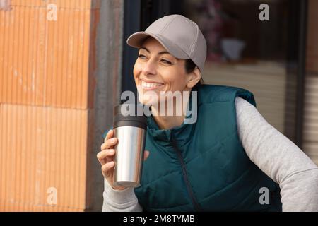 femme tenant une tasse isolée pendant la pause sur le chantier de construction Banque D'Images