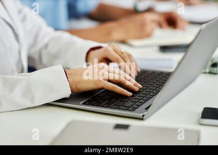 Gros plan de la jeune femme médecin dactylographiant sur le clavier de l'ordinateur portable pendant un séminaire médical ou un cours, espace de copie Banque D'Images