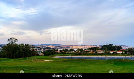 observer le lever du soleil depuis le brut avec la ville de la coruña en arrière-plan et le lac de campagne en premier plan Banque D'Images