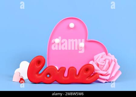 Décoration de Saint-Valentin avec mot rouge amour, roses et ornements coeur sur fond bleu Banque D'Images