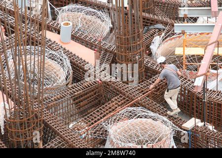 Le travailleur dans le chantier de construction près des armatures Banque D'Images