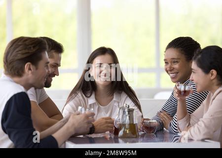 Une équipe diversifiée d'amis heureux et joyeux bavardant et riant Banque D'Images