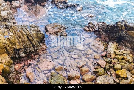 Rochers et pierres dans l'eau avec des oursins à Zicatela Puerto Escondido Oaxaca Mexique. Banque D'Images