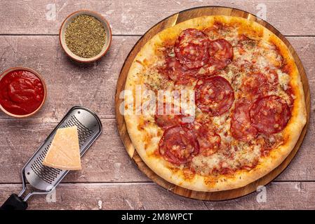 Photographie alimentaire de pizza, salami, parmesan, fromage, tomate, sauce, origan, épicée Banque D'Images