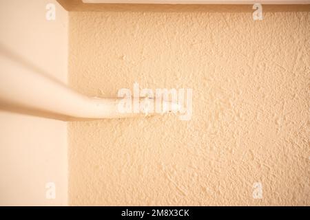 Vieille maison avec tuyau d'eau de chauffage à l'extérieur du mur à l'intérieur d'une maison Banque D'Images
