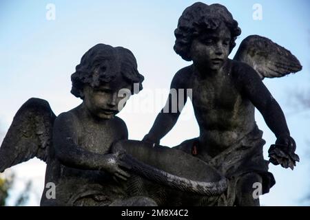 Les deux « putti » - enfants aidés - dispersent des fleurs sur la tombe du cimetière Albert Emile Schloss Brompton, à l'ouest de Londres Banque D'Images