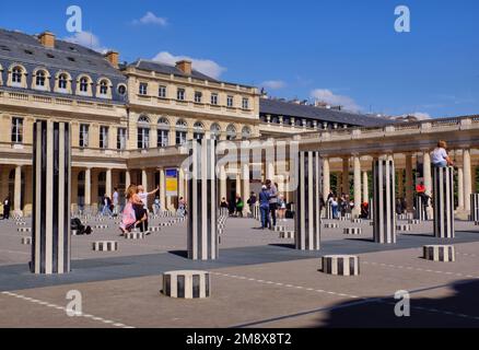 Paris: Personnes appréciant les colonnes de Buren (les deux plateaux) par Daniel Buren au cours d'Honneur du Palais Royal, Paris, France Banque D'Images