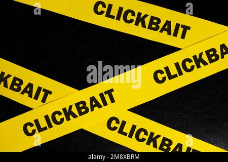 Concept d'alerte, de prudence et d'avertissement de l'escroquerie de Clickappât. Ruban de barricade jaune avec le mot clickappât sur fond noir foncé. Banque D'Images