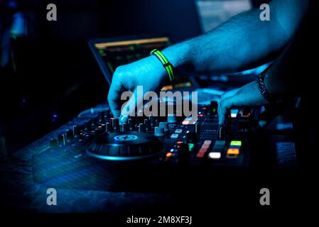 DJ Hand mixe de la musique électronique sur un mixeur professionnel dans une boîte de nuit lors d'une fête Banque D'Images