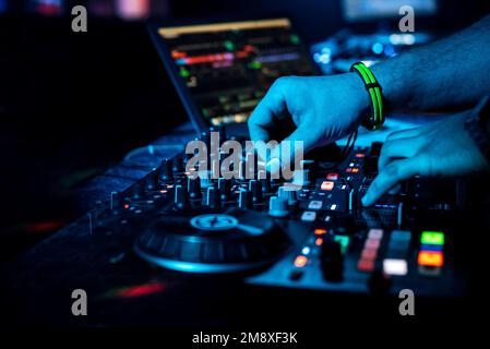 DJ Hand mélange de la musique électronique sur un mélangeur professionnel dans une boîte de nuit lors d'un concert Banque D'Images