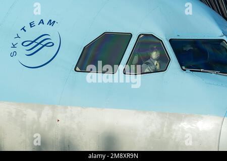 Séoul, Corée. 22nd décembre 2022. Un pilote de compagnie aérienne regarde par une fenêtre un Airbus A330 Korean Air est préparé pour un vol vers le Japon par l'équipage de la rampe de chargement de fret, de bagages et de fournitures de restauration à des températures glaciales.Korean Air (KE) est la compagnie aérienne du porte-drapeau de la Corée du Sud, basée à Séoul. C'est l'une des 20 compagnies aériennes les plus populaires au monde et membre de l'alliance SkyTeam. La compagnie aérienne exploite son principal centre à l'aéroport international d'Incheon (ICN) et son centre secondaire à l'aéroport international de Gimpo (GMP) à Séoul. Korean Air propose des vols intérieurs et internationaux vers la destination Banque D'Images