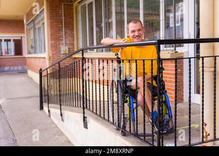 Portrait d'une personne handicapée vêtue de jaune en fauteuil roulant à l'école en souriant Banque D'Images