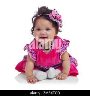 Innocente, mignonne et heureuse petite fille dans un studio avec un ensemble floral, beau et floral et un bandeau. Bonheur, sourire et bébé enfant assis et Banque D'Images