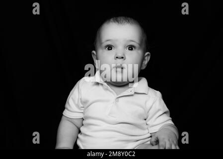 Portrait noir et blanc de joli petit bébé drôle. Visage d'enfant de race blanche Banque D'Images