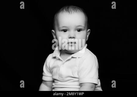 Portrait noir et blanc de joli petit bébé drôle. Visage d'enfant de race blanche Banque D'Images