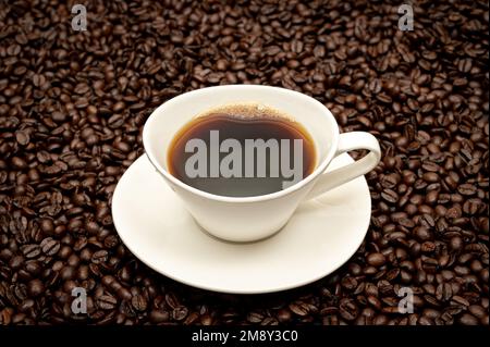 Tasse de café sur grains de café bruns Banque D'Images