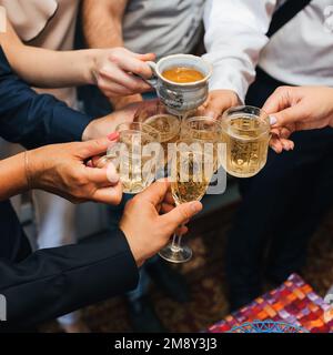 mains d'un groupe d'amis qui se trinquent des verres de boisson alcoolisée et toaster et féliciter pour les vacances au restaurant Banque D'Images