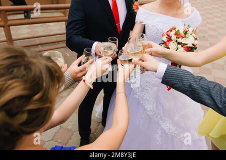 les invités au mariage clink verres de champagne et félicitent la mariée et le marié Banque D'Images