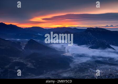 Lever du soleil dans la vallée de Vall de Lord avec brouillard sur le réservoir et nuages rougeâtres. Vue de Port del Comte (Solsonès, Lleida, Catalogne, Espagne) Banque D'Images