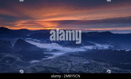 Lever du soleil dans la vallée de Vall de Lord avec brouillard sur le réservoir et nuages rougeâtres. Vue de Port del Comte (Solsonès, Lleida, Catalogne, Espagne) Banque D'Images