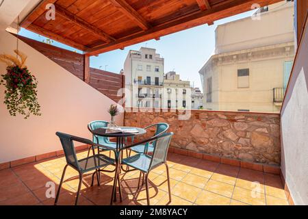 Grande terrasse avec un toit en bois donnant sur la ville avec un ciel bleu. Sur la terrasse inondée de lumière du soleil au milieu il y a un Banque D'Images