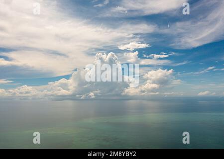 De beaux nuages blancs sur le ciel bleu au-dessus de la mer calme. Harmonie tranquille de la mer d'une surface d'eau calme. Ciel ensoleillé et océan bleu calme. Banque D'Images