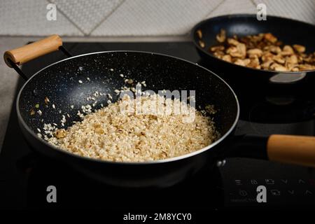 Processus de cuisson du risotto. Riz Arborio dans une poêle à frire dans la cuisine maison. Plat de cuisine italienne Banque D'Images