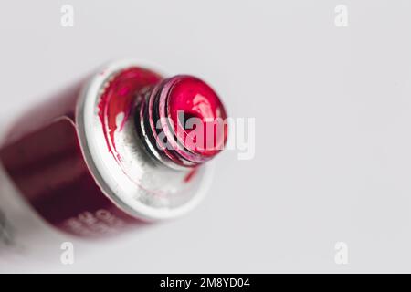 Tube en acrylique métallique avec peinture rose pour dessiner des gros plans sur fond blanc. Banque D'Images
