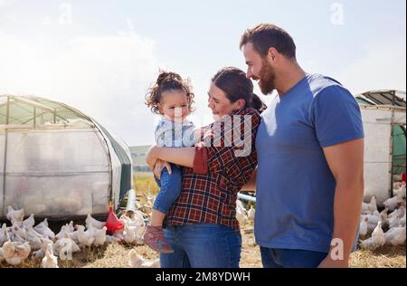 Vivre une vie simple mais épanouissante. un couple et leur adorable fille dans une ferme avicole. Banque D'Images