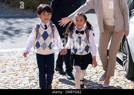 Un jeune couple vient chercher les enfants de l'école Banque D'Images