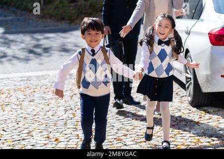 Un jeune couple vient chercher les enfants de l'école Banque D'Images