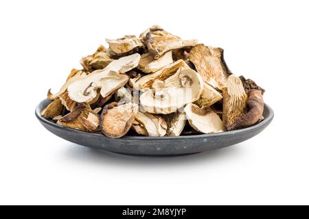 Divers champignons séchés en tranches dans une assiette isolée sur fond blanc. Banque D'Images