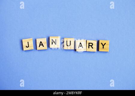 Inscription janvier faite par des cubes en bois sur fond veri peri violet Banque D'Images