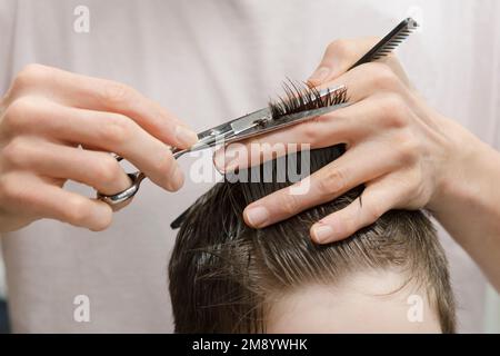 Un petit garçon dans un salon de coiffure Banque D'Images