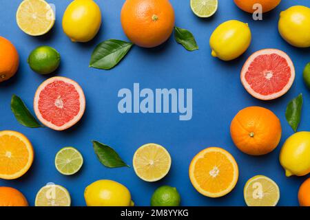 Plat d'agrumes comme le citron vert, l'orange et le citron avec des feuilles de citronniers sur fond clair de couleur faisant un cadre. Espace pour texte sain concep Banque D'Images