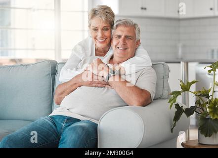 Vous avez volé mon cœur mais vous le laissez tomber. un heureux couple senior se détendant sur le canapé à la maison. Banque D'Images