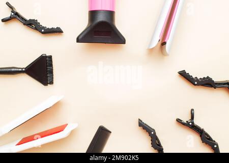 divers outils de coiffure comme sèche-cheveux, peigne sur fond beige. concept de salon de beauté. Banque D'Images