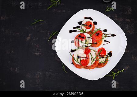 Salade Caprese avec tomate, mozzarella et arugula en forme d'arbre de Noël. Vue de dessus, au-dessus de la tête Banque D'Images