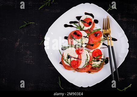 Salade Caprese avec tomate, mozzarella et arugula en forme d'arbre de Noël. Vue de dessus, au-dessus de la tête Banque D'Images