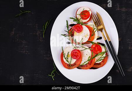 Salade Caprese avec tomate, mozzarella et arugula en forme d'arbre de Noël. Vue de dessus, au-dessus de la tête Banque D'Images