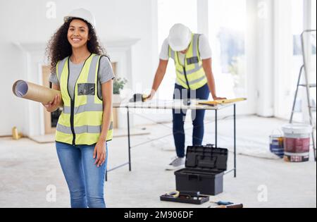 Faisait ce que nous faisons le mieux. un jeune entrepreneur attrayant se tenant à l'intérieur et tenant des plans de construction. Banque D'Images