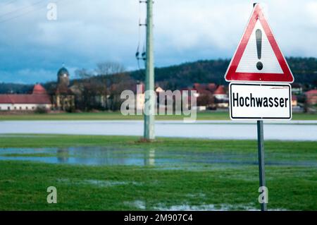 16 janvier 2023, Bavière, Untermerzbach-Memmelsdorf: Un panneau indique la haute eau près de Hemmendorf avec une vue de Lahm (en arrière-plan). Entre Hemmendorf (municipalité d'Untermerzbach, district de Hassberge) et Lahm (municipalité d'Itzgrund, district de Coburg), les prés sont sous l'eau et la route reliant les deux villes est fermée. Photo: PIA Bayer/dpa Banque D'Images